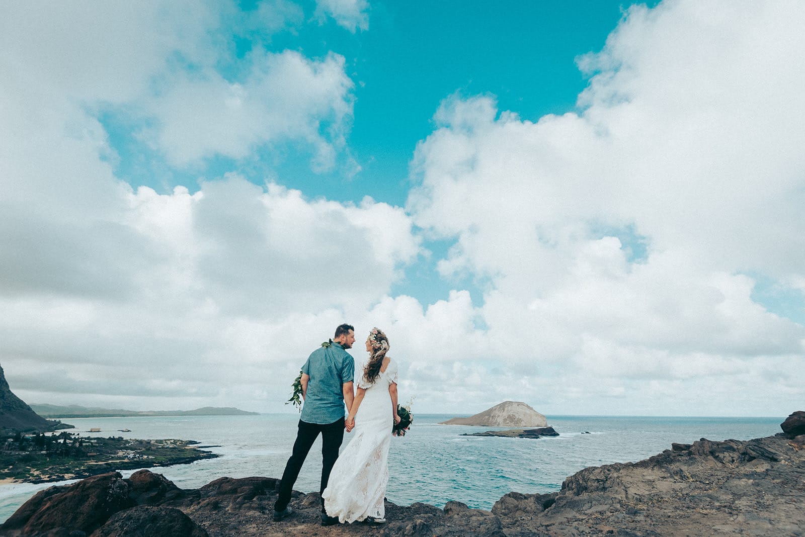 A couple on the ridge at Makapu'u Lookout, the ocean and Rabbit Island behind